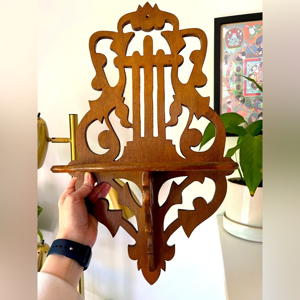 Handmade wooden shelf with musical instrument design.